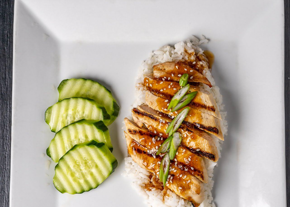 Plated Teryaki Chicken over rice with cucumber slice as a side